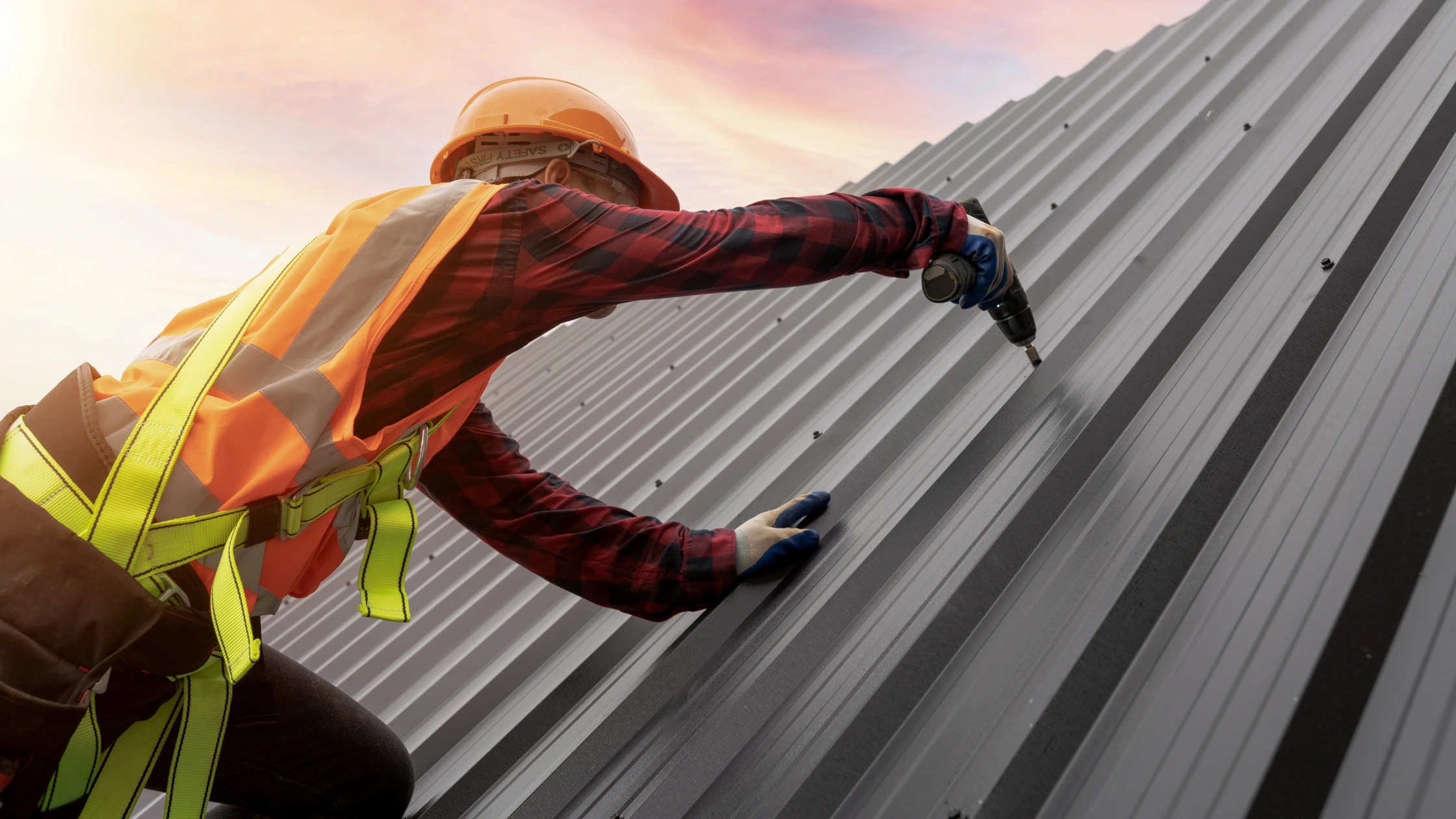 A roofing technician installing a long-last metal roof made of copper on a home in Phoenix
